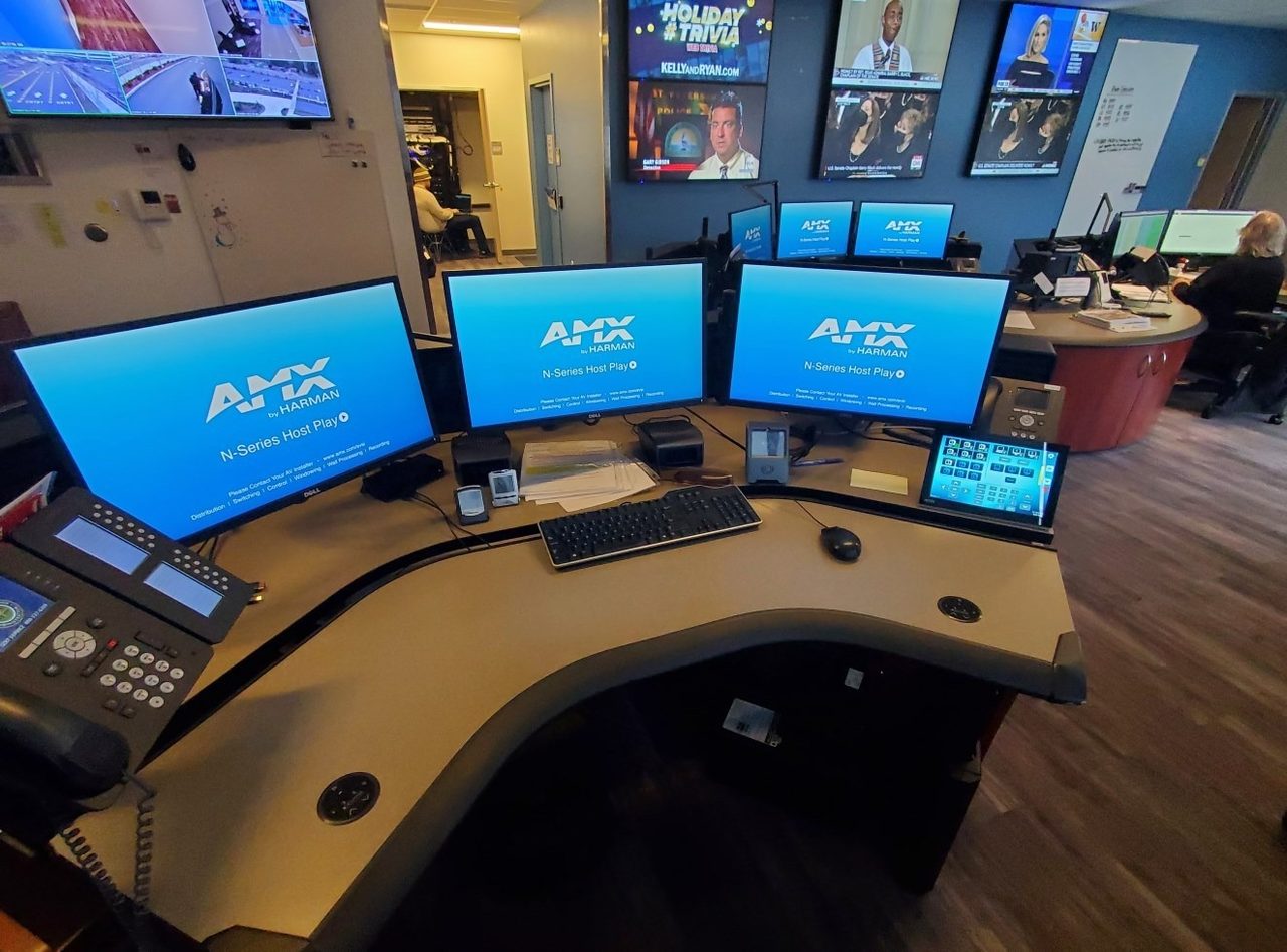 24/7 operations center with AMX control and a wall of live-feed displays